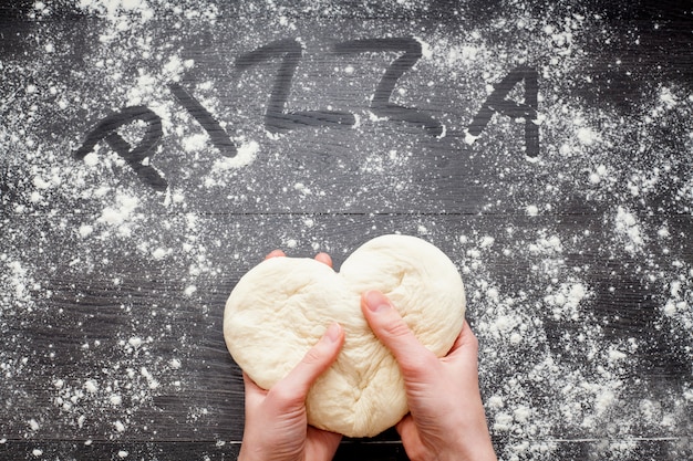 Photo hands kneading the dough on a table