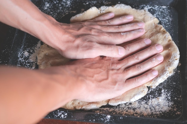 写真 背中のシートでキッチンでパンを作っている間,手でペーストを ⁇ む