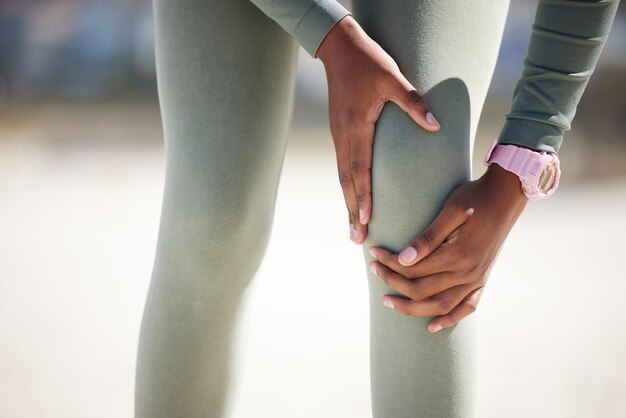 Foto infortunio al ginocchio delle mani e atleta all'aperto con dolore durante l'esercizio in esecuzione o allenamento artrite fitness o gamba della persona con problema di ferita fibromialgica o incidente di emergenza durante l'allenamento sportivo