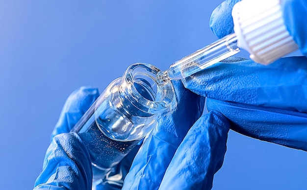 Hands of a lab technician with a tube of blood sample lab assistant holds a blood test tube for research The taking of biological material to identify the virus the flu Copy space