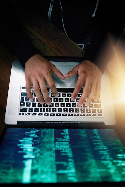 ソフトウェア開発のためにキーボードを入力しながらコーディングする男性プログラマーとノートパソコンとオーバーヘッドを手にするオフィスの男性プログラマーとコンピューター言語情報技術とサイバースペース
