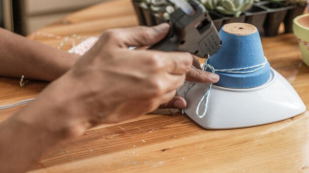 Mani di una donna mulatta latina che dipinge vasi di terracotta per piantare piante succulente