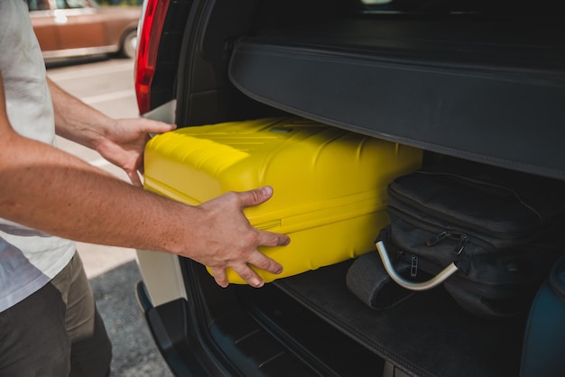 Hands load bags in car trunk