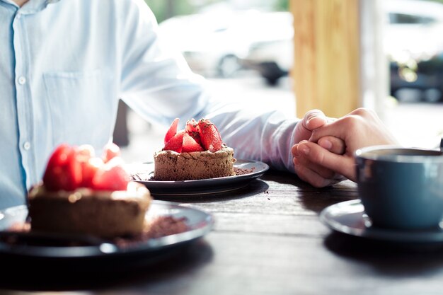 Hands of a loving couple at a table in a cafe