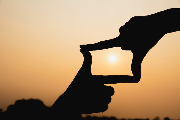 Hands making frame with sunset