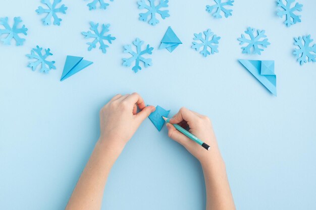 写真 青い子供の手で紙の雪粒を作る手 高品質の写真