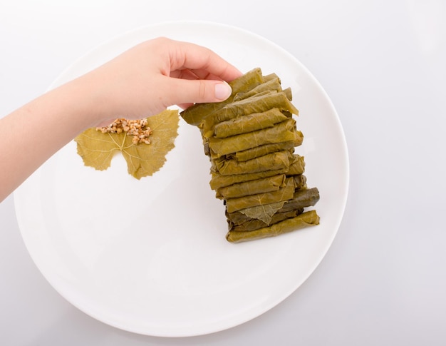 Hands making stuffed grape leaves in Turkish style