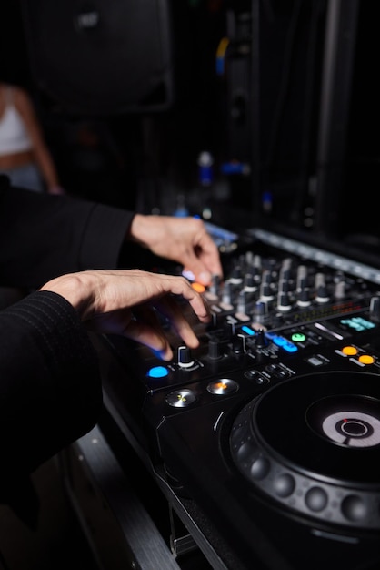 Hands of male Dj playing music on modern midi controller turntable Digital device for mixing music on events and in studio