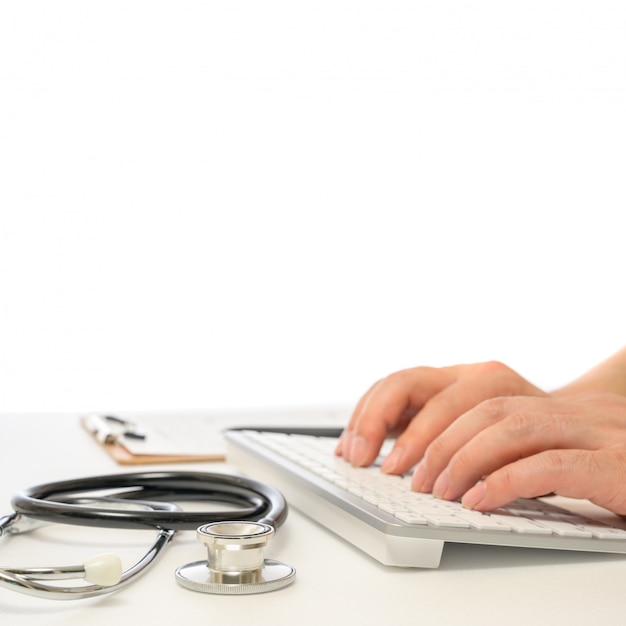 Hands of a male doctor who uses a computer keyboard.