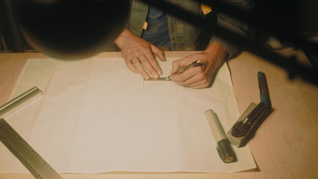 Hands of male engineer works with drawings lying sketch