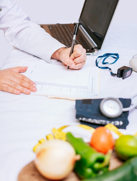 Hands of male nutritionist taking notes at his desk Nutritionist hands taking medical records in the office Closeup of nutritionist writing on notepad