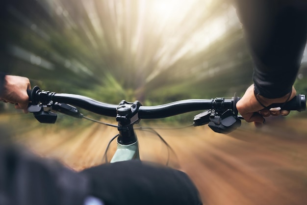 Mani l'uomo e le abilità di ciclismo mentre si è in bicicletta all'aperto in una foresta i drogati di adrenalina si allenano o gareggiano velocemente negli sport estremi in bicicletta con resistenza e cardio durante un allenamento fuoristrada