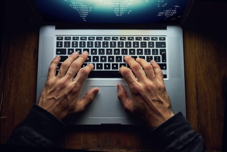 Photo hands man and laptop for hacking at night database software and hacker for cyber attack keyboard programming malware and spam system or algorithm for phishing thief and coding script above