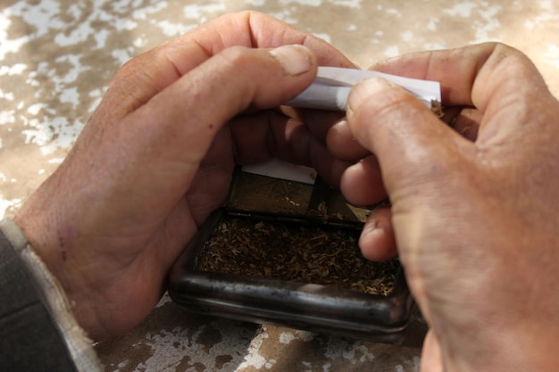 Hands of a man rolling a cigarette