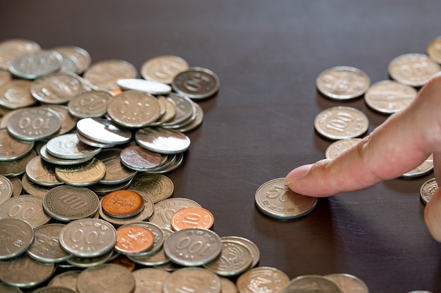 the hands of a man sorting stacked coins.