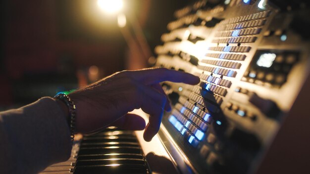 Photo hands of a man sound engineer are pressing buttons on the console