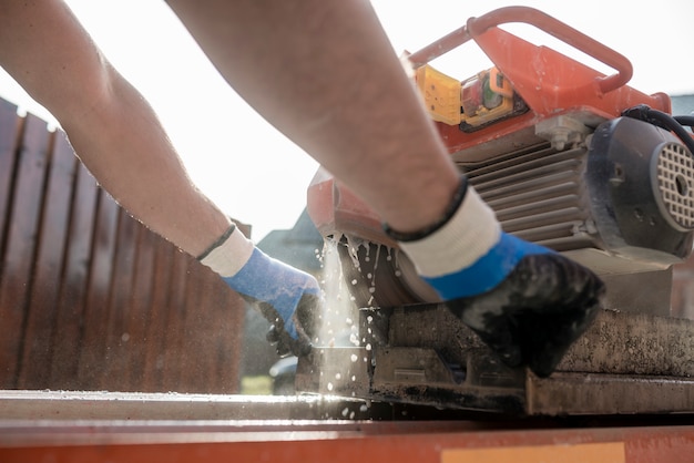 The hands of a man using an angle grinder