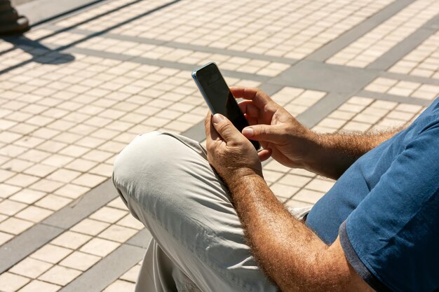 Photo hands of man using smartphone on the street