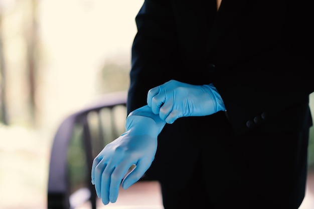 The hands of a man wearing blue gloves preparing for an event