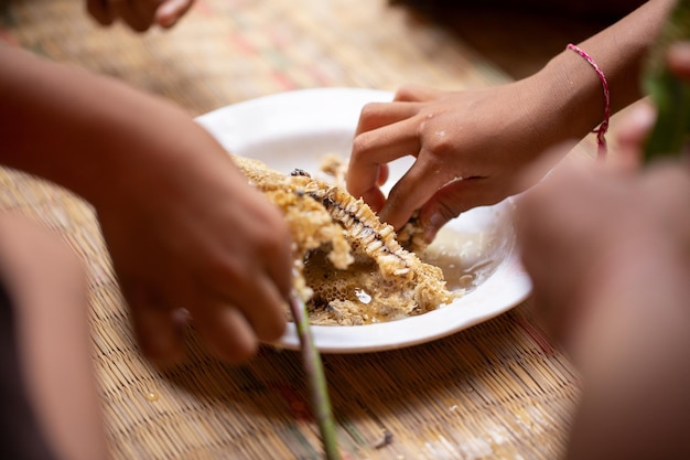 Le mani di molte persone si stanno arrampicando per mangiare gli alveari su un piatto bianco con gioia e felicità