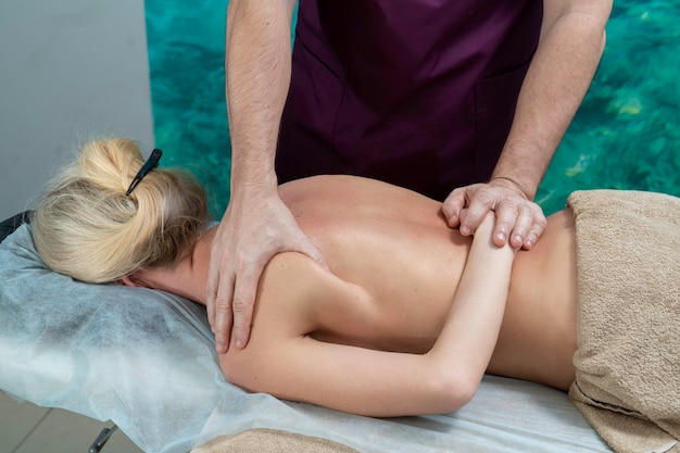 Photo hands of a massage therapist massaging a woman