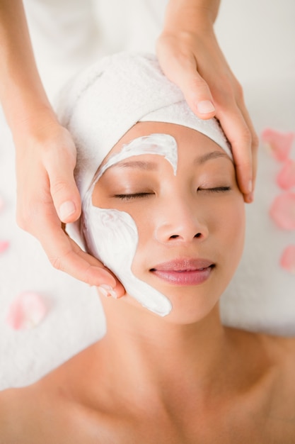 Hands massaging womans face at beauty spa