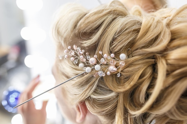 Foto le mani del maestro fanno i capelli della sposa prima del matrimonio