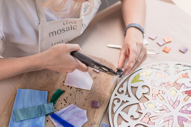 Photo hands of master working on new modern colorful mosaic. close-up