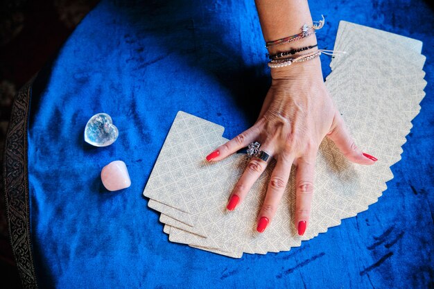 Hands of a mature woman with tarot cards - unpredictable future concept