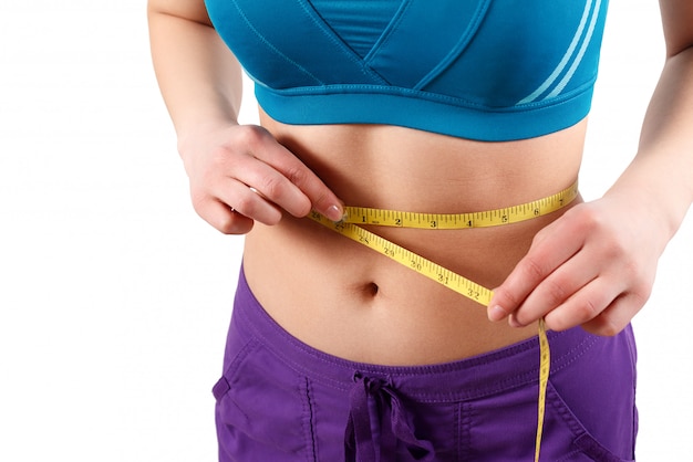 hands measuring waist with a tape on white