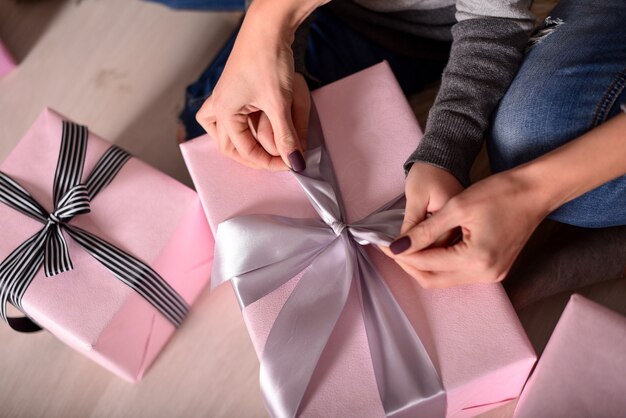 Photo the hands of mother and daughter unpacking a gifts