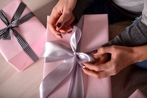 The hands of mother and daughter unpacking a gifts