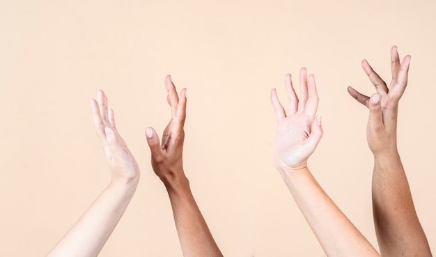 Hands of multiethnic women, on beige background