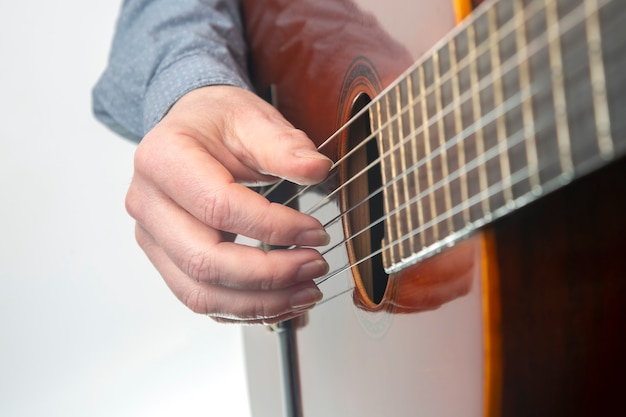 Hands of the musician playing on classical guitar