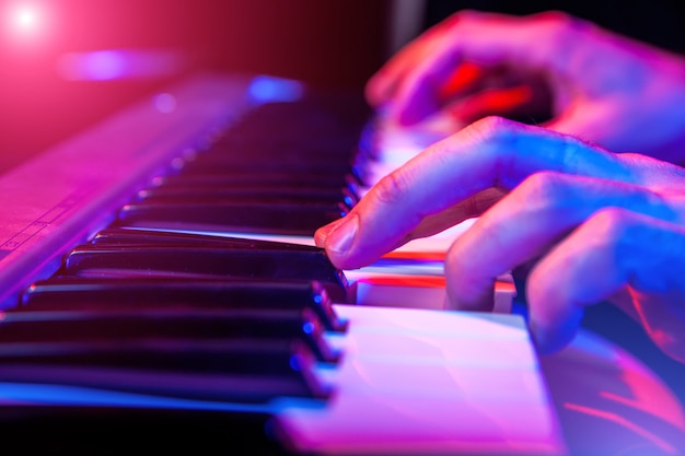 Hands of musician playing keyboard in concert 