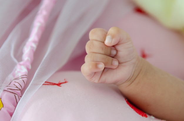 hands of the newborn baby on the bed