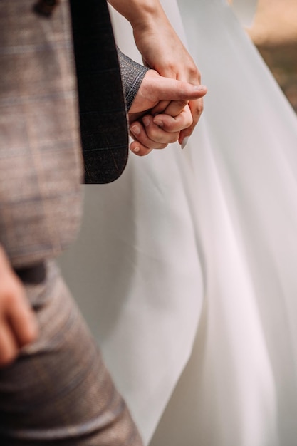 The hands of the newlyweds are holding each other going forward 4329