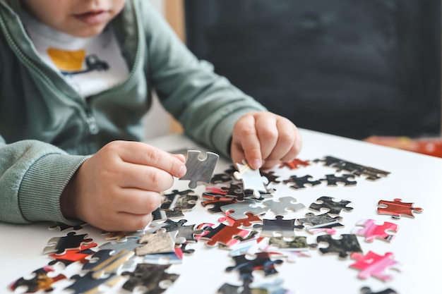 写真 テーブルでパズルをしている子供の手