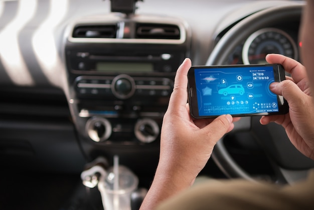 Фото Руки человека, использующие мобильное приложение для анализа автомобильных мобильных телефонов в автомобиле