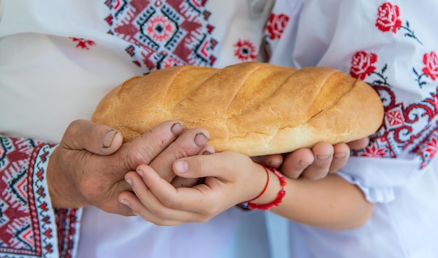 Фото Руки пожилой женщины с девочкой, держащей хлеб