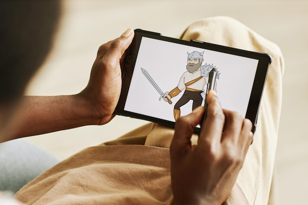 사진 creat 동안 태블릿 화면에 전사의 그래픽 그림을 그리는 스타일러스와 젊은 흑인 남자의 손
