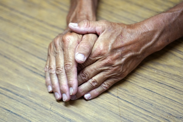 Le mani del vecchio sul tavolo