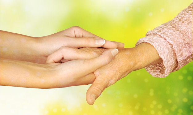 Hands of the old man and a young woman. close up.