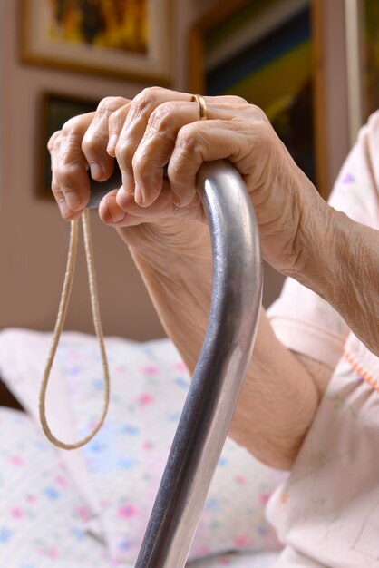 Photo hands of old woman on a cane