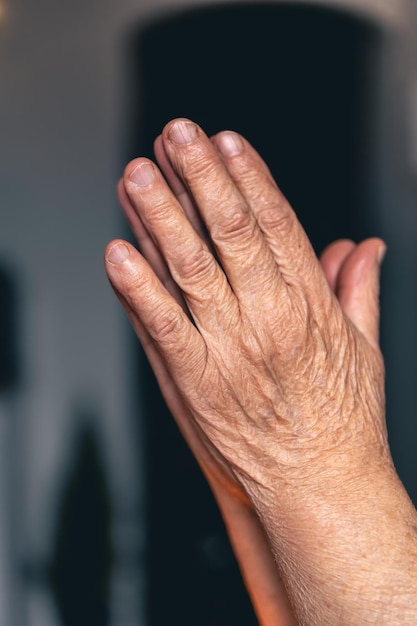 Руки старухи сложены для молитвы