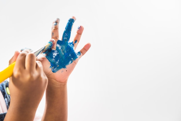 Photo hands in paint with brush in studio