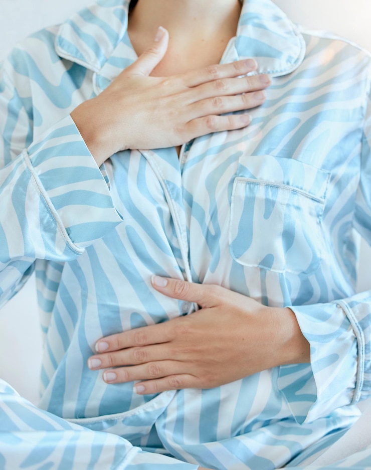 Photo hands pajamas and morning with a woman breathing after waking up in her bedroom after a relaxing rest health body and breath with a female sitting alone on her bed to relax early in the day