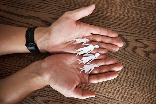 Hands paper cutout family and home on table for sign symbol or icon of support love or solidarity Art design with mother father and kids holding hands for trust care or together in community