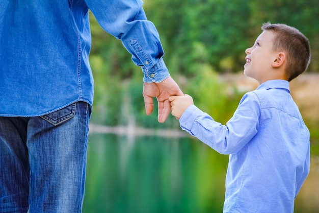 Photo a hands of parent and child in nature in the park travel