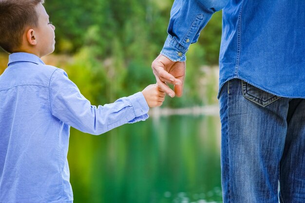 A Hands of parent and child in nature in the park travel